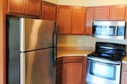 a kitchen with stainless steel appliances and wooden cabinets