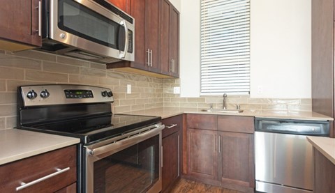 A kitchen with a stove top oven and microwave above it.