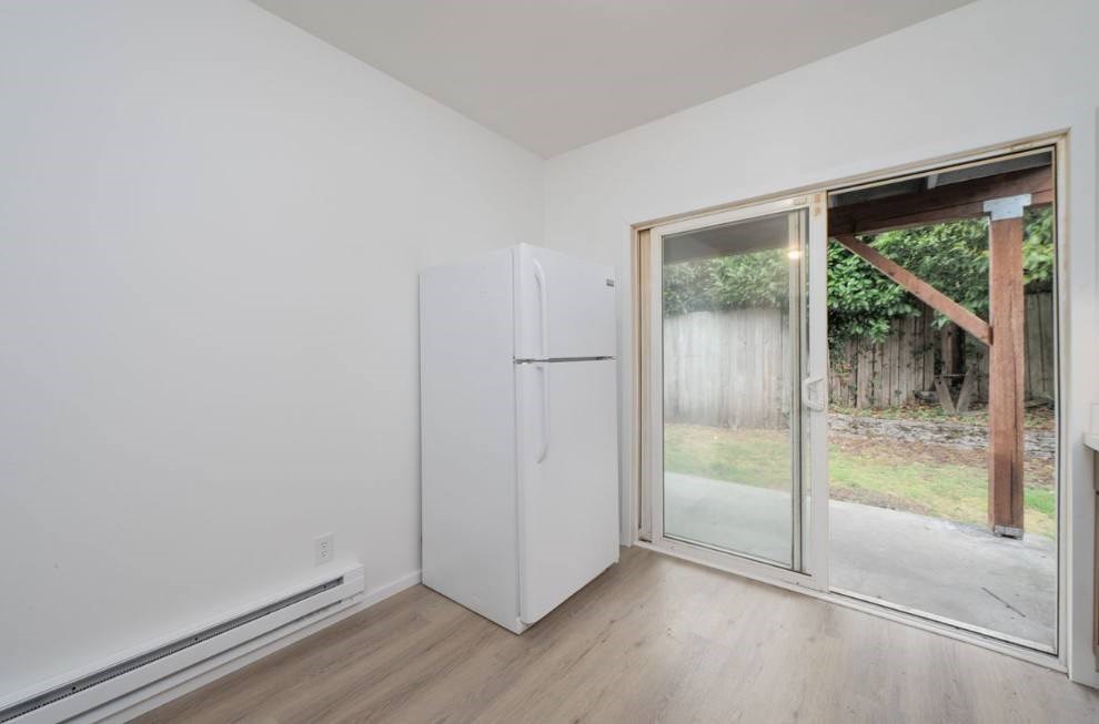 A white refrigerator in a room with a sliding glass door.