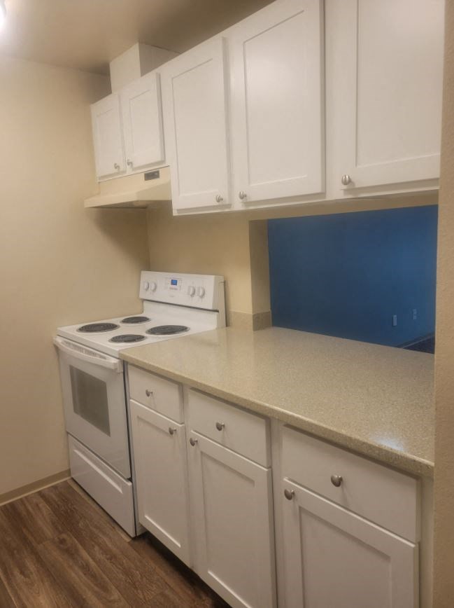 a kitchen with white cabinets and a stove top oven