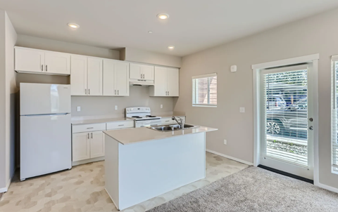 A kitchen with white appliances and cabinets.