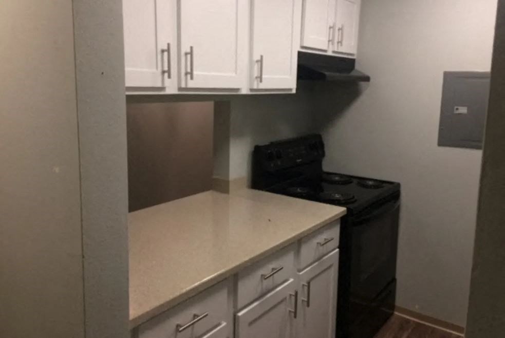 a kitchen with white cabinets and a black stove