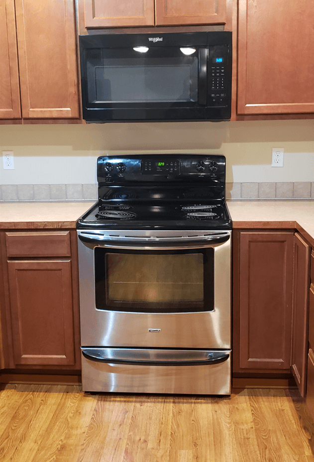 a kitchen with a stainless steel stove and a microwave