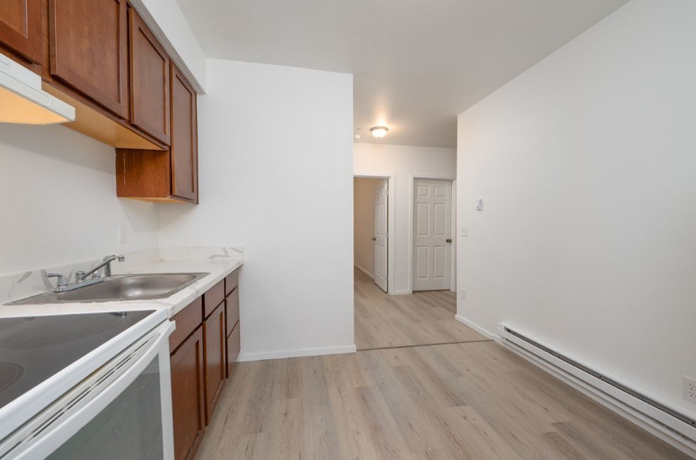 A kitchen with wooden cabinets and a stainless steel sink.