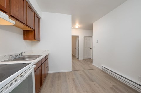 A kitchen with wooden cabinets and a stainless steel sink.