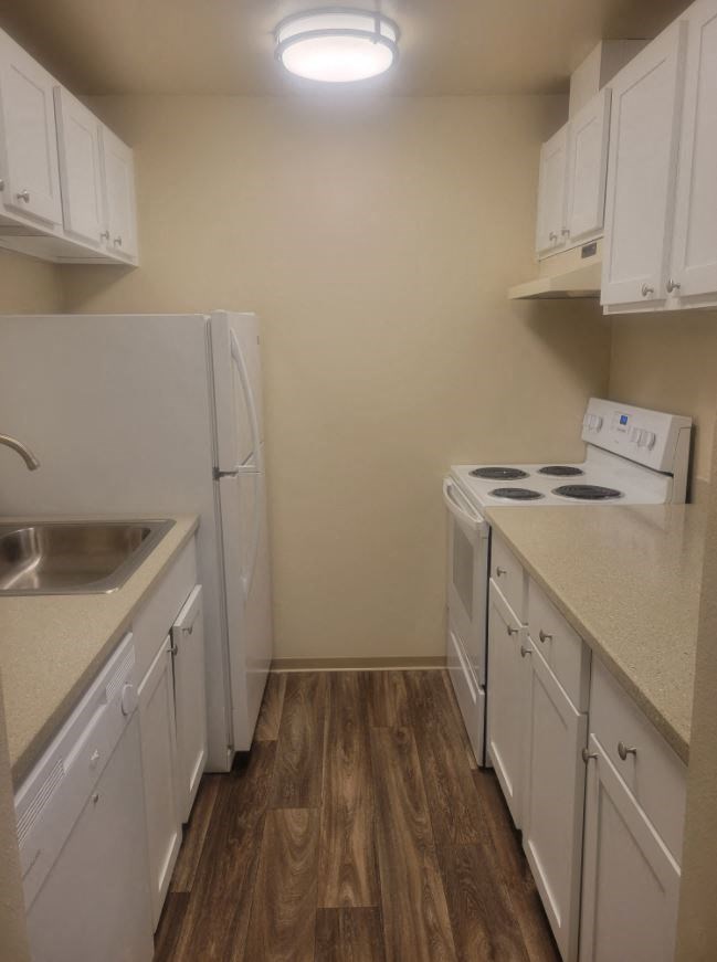 a kitchen with a stove refrigerator and a sink