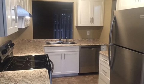 a kitchen with granite counter tops and stainless steel appliances