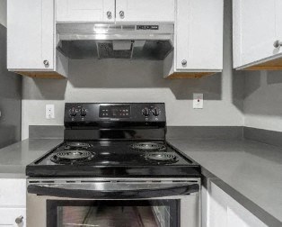 a kitchen with white cabinets and a black stove