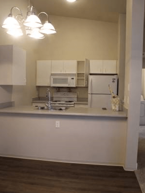 an empty kitchen with a microwave and a refrigerator