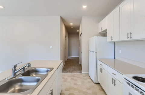 A kitchen with white cabinets and a sink.