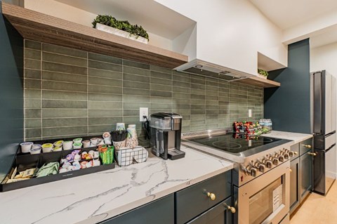 A kitchen with a black oven and a marble countertop.