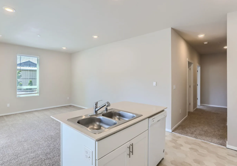 A kitchen with white cabinets and a sink.