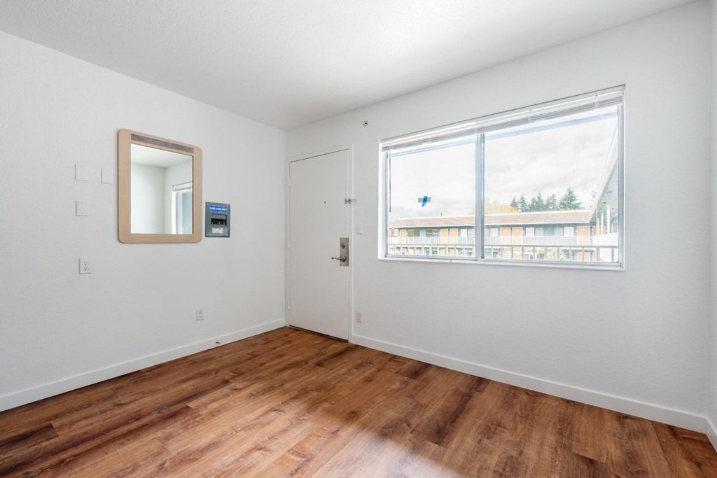 A room with a wooden floor and a large window.