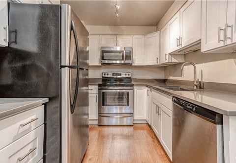 a kitchen with stainless steel appliances and white cabinets