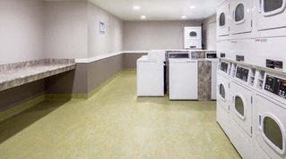 a laundry room filled with lots of white washing machines