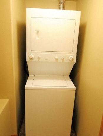 a white washer and dryer in a small bathroom