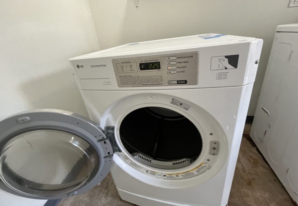 an empty living room with a washer and dryer in it