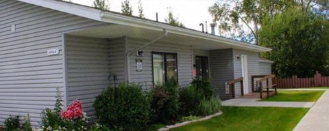 a gray house with a front porch and a porch swing