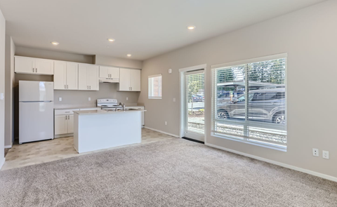 A spacious kitchen with white appliances and a large island.