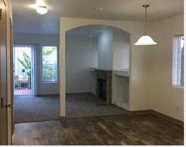 an empty living room with a fireplace and a doorway