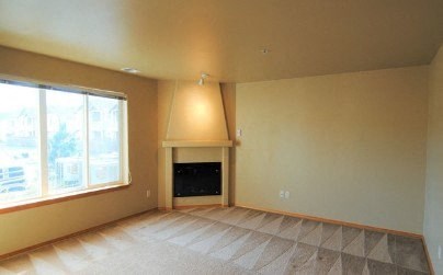 a living room with a fireplace and a large window