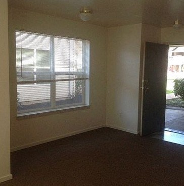 an empty room with a window and a door