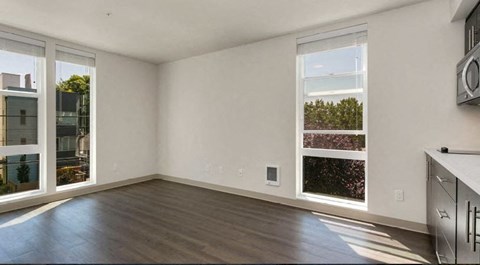 an empty living room with wood floors and windows