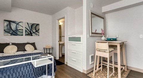 a bedroom with a bed and a desk and a mirror