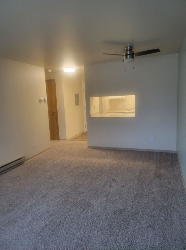 a empty living room with a ceiling fan in it