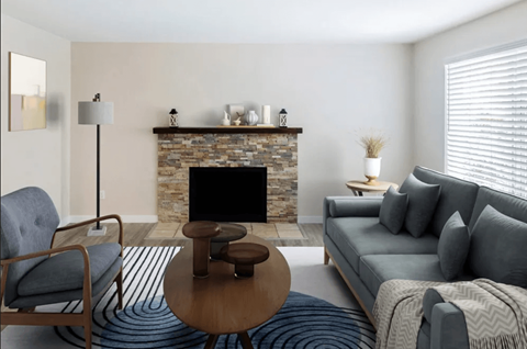 A living room with a grey couch, a wooden coffee table, and a fireplace.