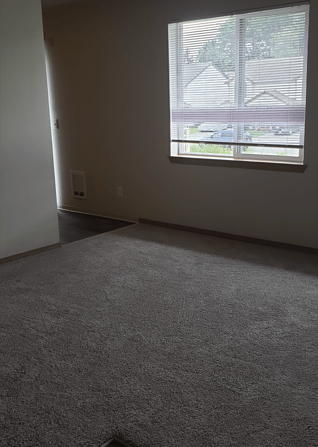 an empty living room with a large window