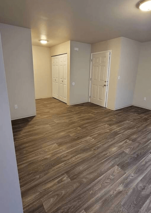 a empty room with wood flooring and white walls