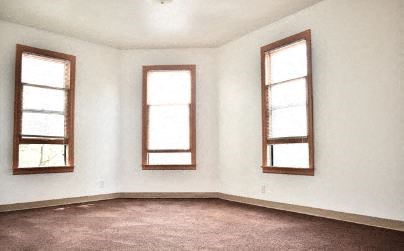 a white room with three windows and a carpet
