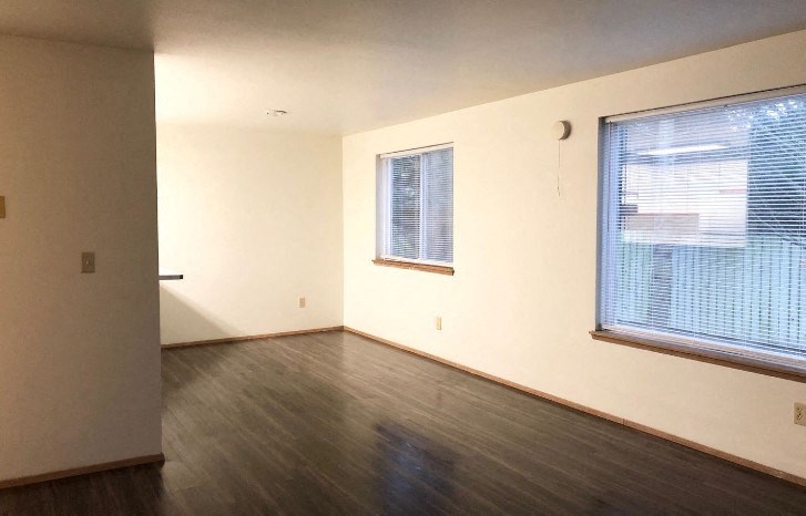 an empty room with a wood floor and a window