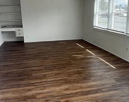 a living room with a wooden floor and a window