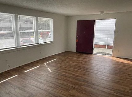 an empty living room with a hard wood floor