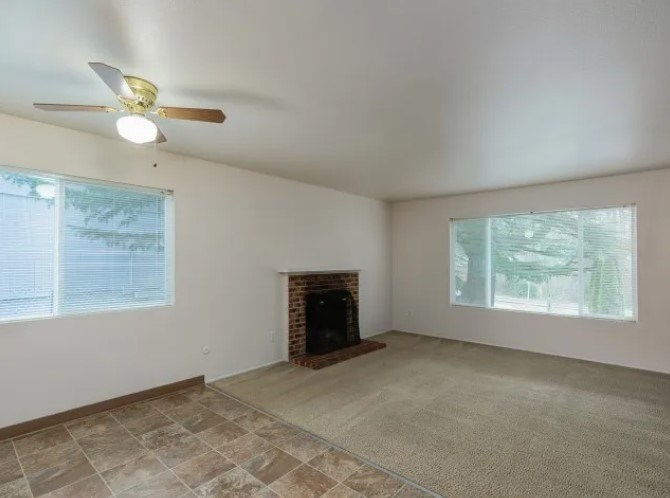 A room with a fireplace and a ceiling fan.