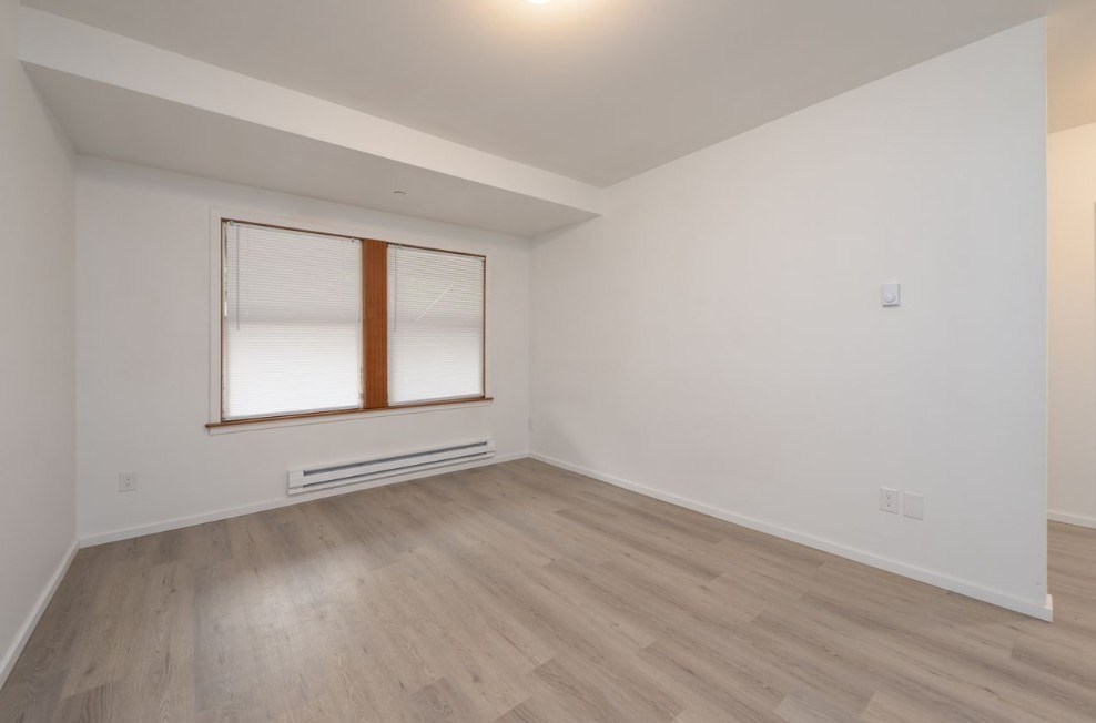 A room with a window and a radiator on the wall.