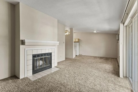 A living room with a fireplace and carpeted floor.