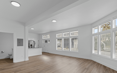 a living room with white walls and a large window