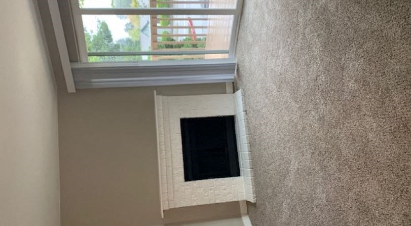 a living room with a fireplace and a window