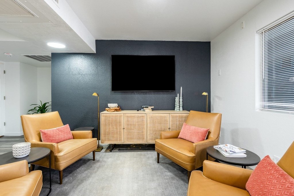 A living room with a flat screen TV mounted on the wall.