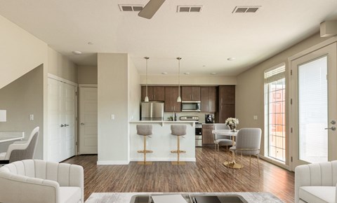 A modern kitchen with white cabinets and a bar area.