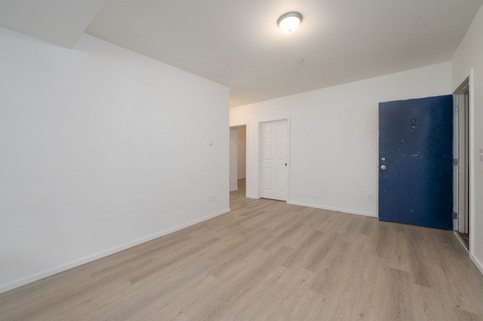 A room with a blue door and white walls.