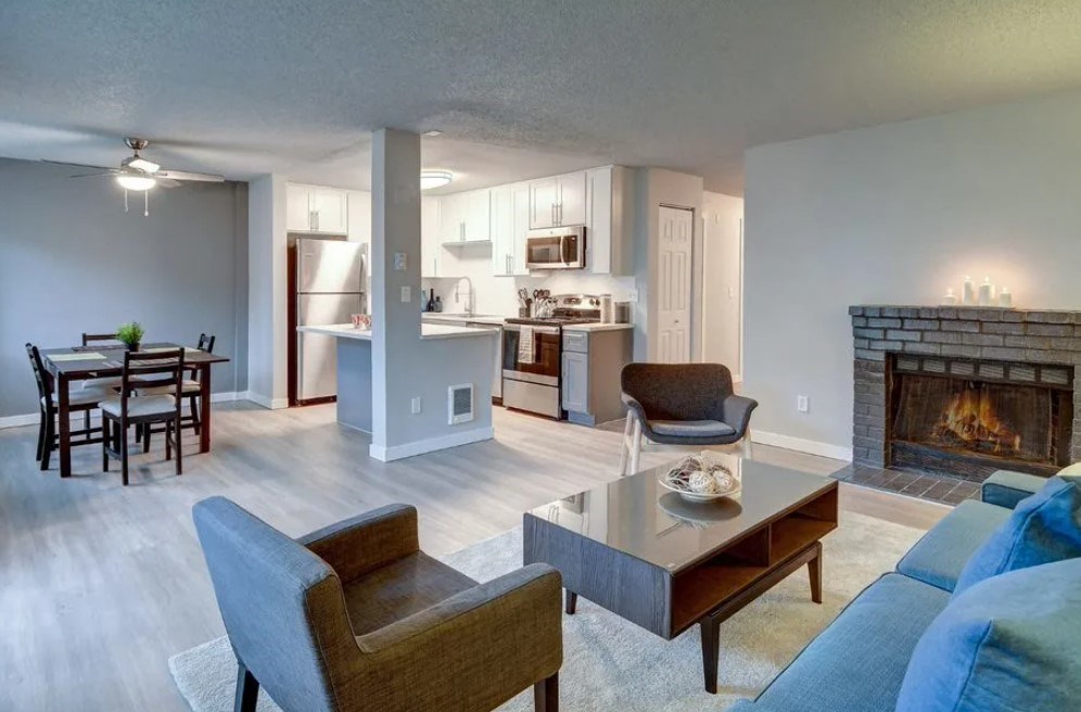 A living room with a fireplace and a dining table.