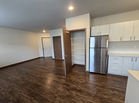 A kitchen with white cabinets and a stainless steel refrigerator.