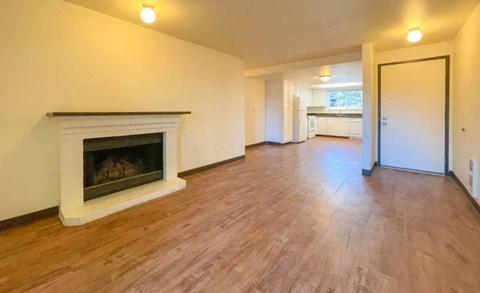 a living room with a fireplace and a wooden floor