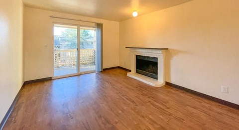 a empty living room with a fireplace and a sliding glass door
