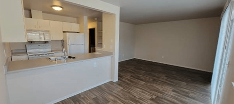 an empty room with a kitchen and a living room