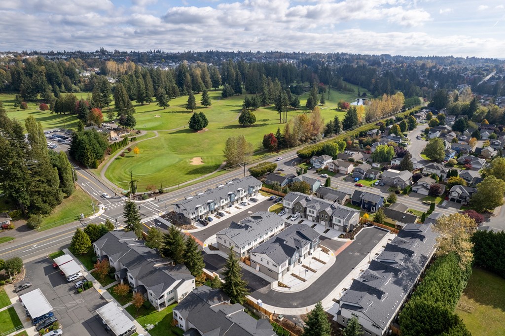 A bird's eye view of a residential area with houses and a parking lot.